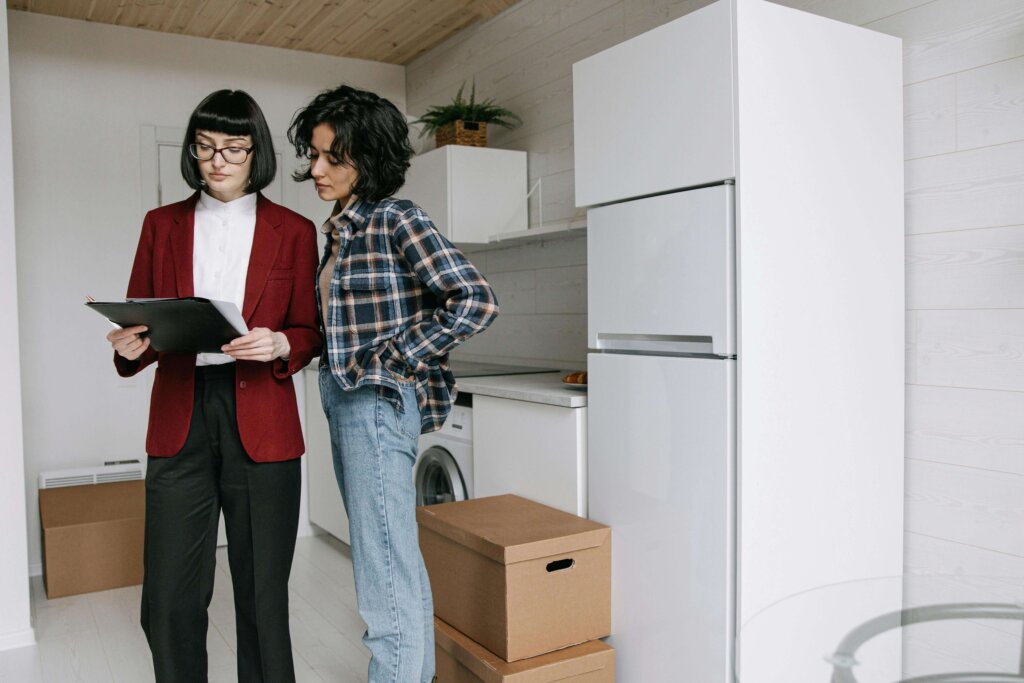 a couple of women standing next to each other in a kitchen
