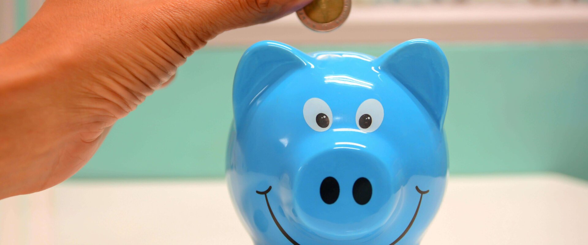 money being put inside a piggybank