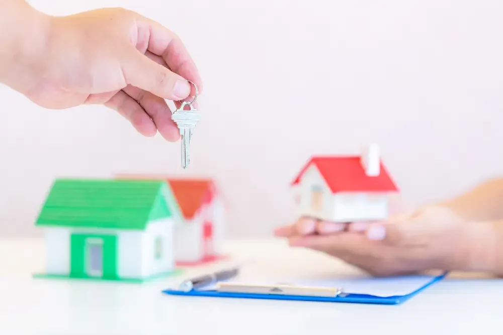 a person handing a house key to another person