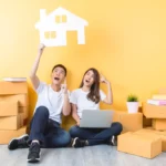 a man and a woman sitting on the floor with a laptop