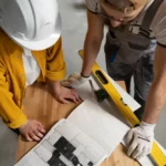 two construction workers looking at a blueprint