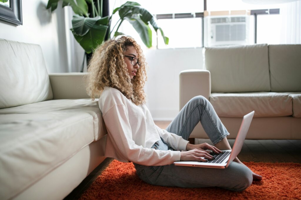 woman at her laptop sitting on the floor in her house in richmond virginia