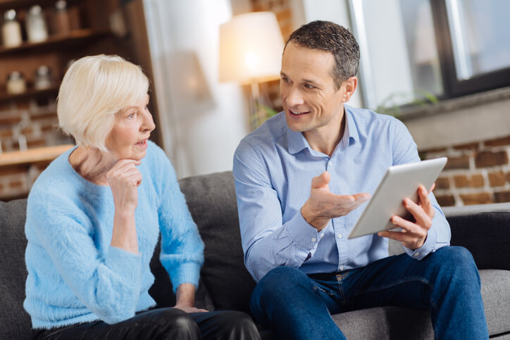 pleasant_man_explaining_how_to-use_tablet_to-his_mother_costs_to_sell_a_house_redmond_bend_prineville_bridgetown_home_buyers