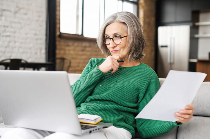 Serious-senior-home-renovation-list-sitting-in-the-living-room-and-looking-at-the-laptop-selling-your-house-salem-keizer-woodburn-bridgetown-home-buyers