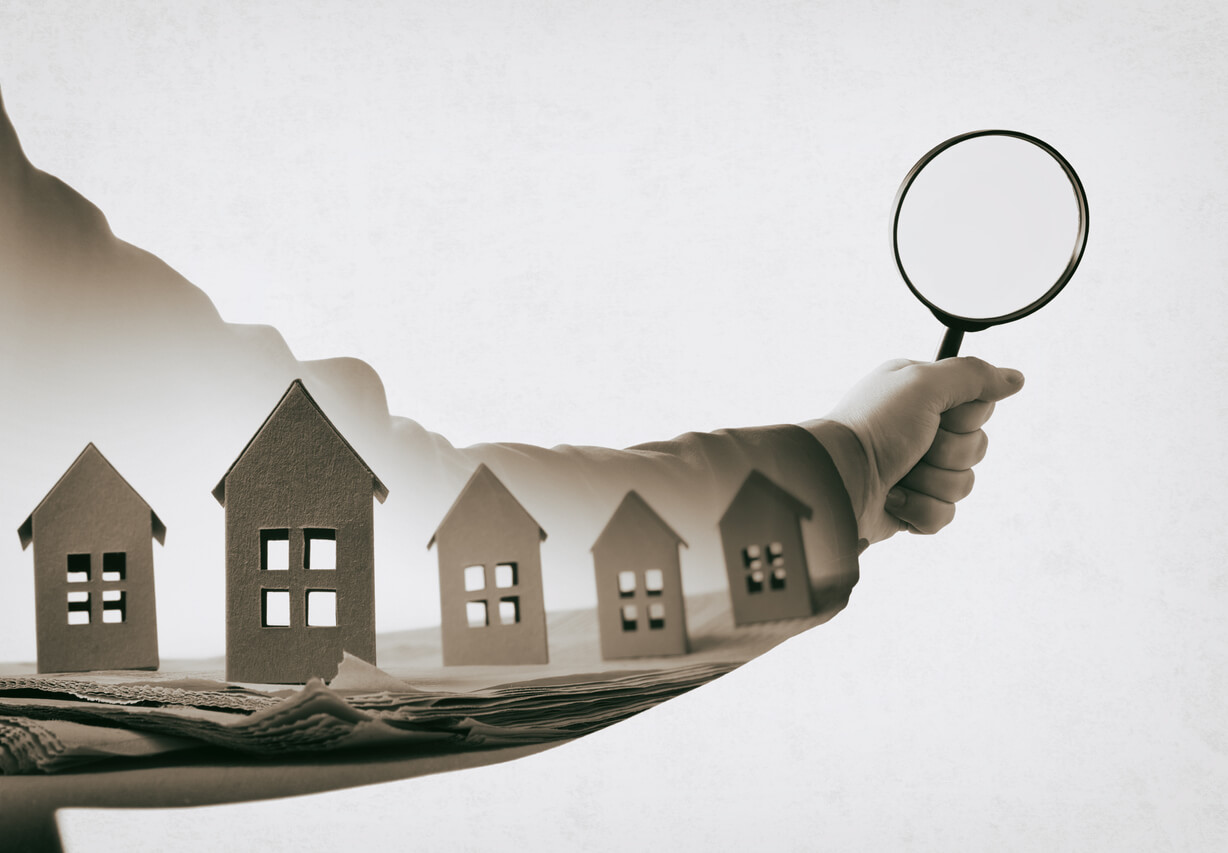 Hand-with-magnifier-and-paper-houses-on-newspaper-sell-my-house-portland-bridgetown-home-buyers