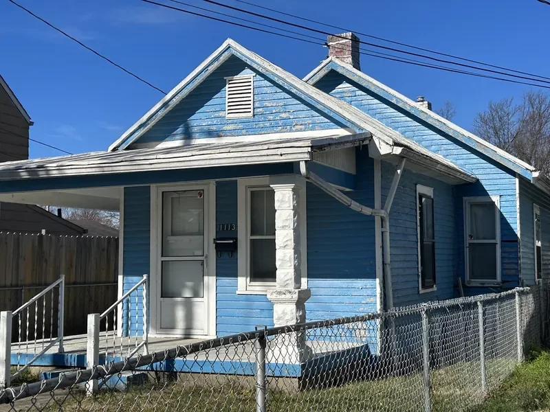 Small blue house with peeling paint in Louisville