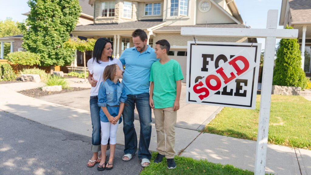 A family posing for the camera in front of a house