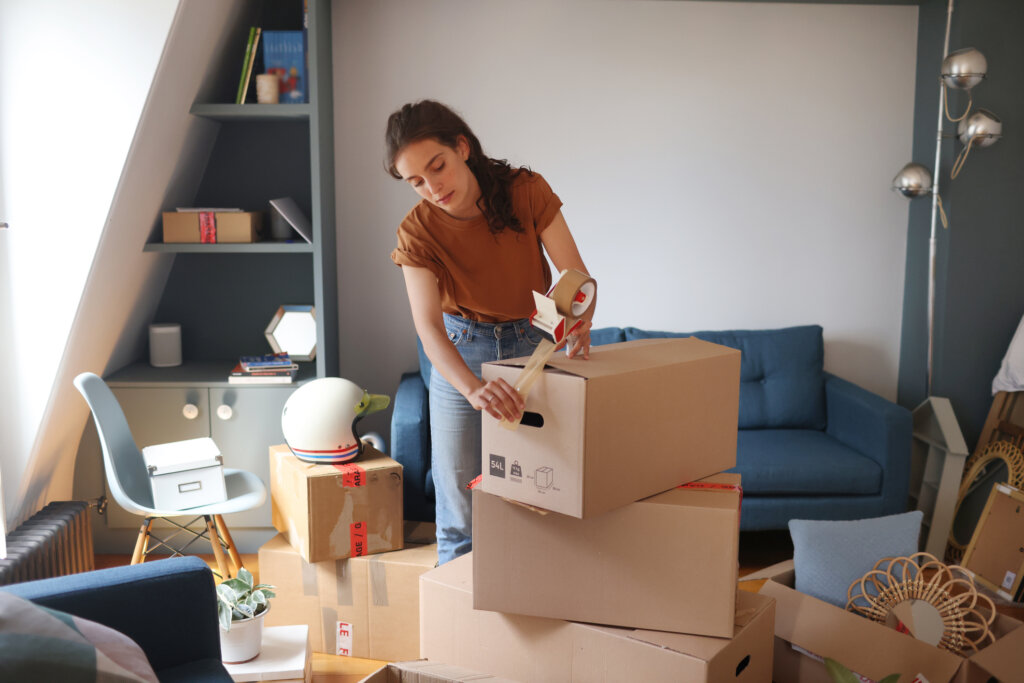 Houston homeowner packing moving boxes before selling a house as-is without repairs or public showings
