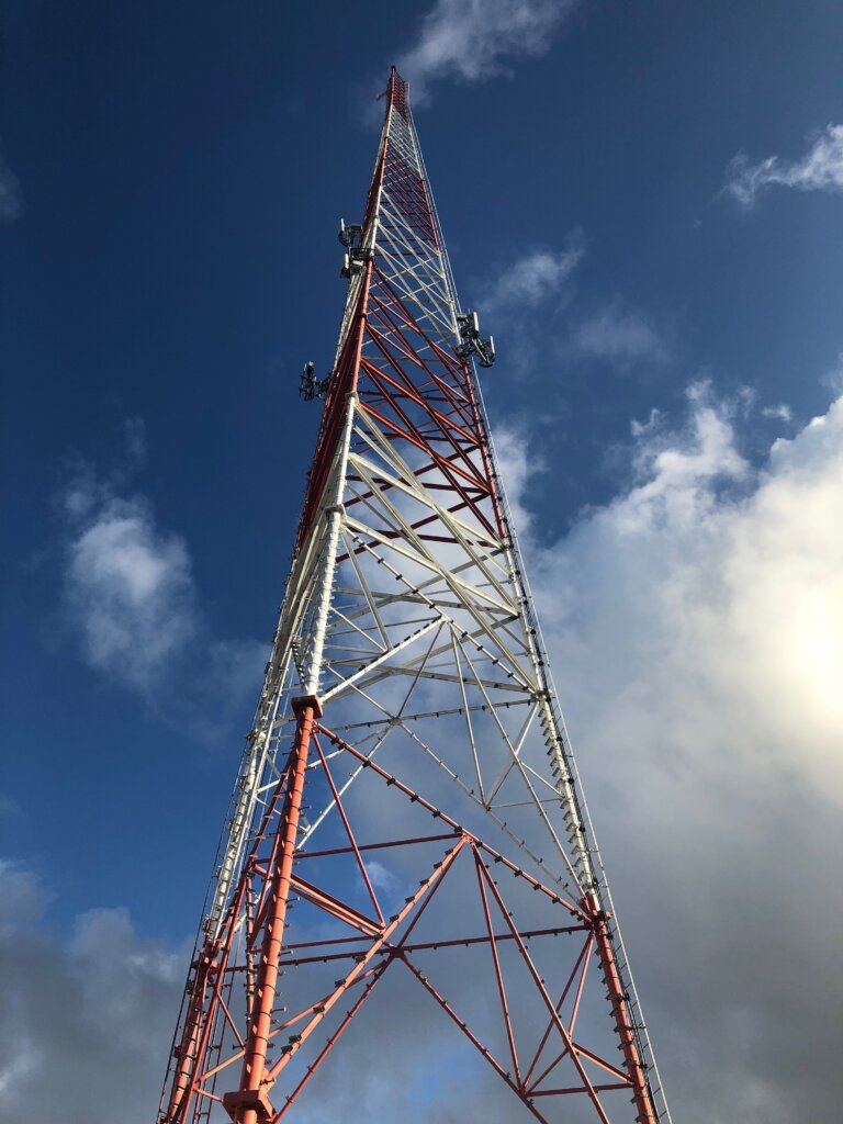 Lattice cell tower site painted red and white. Typically these are painted if they are near a flight path.
