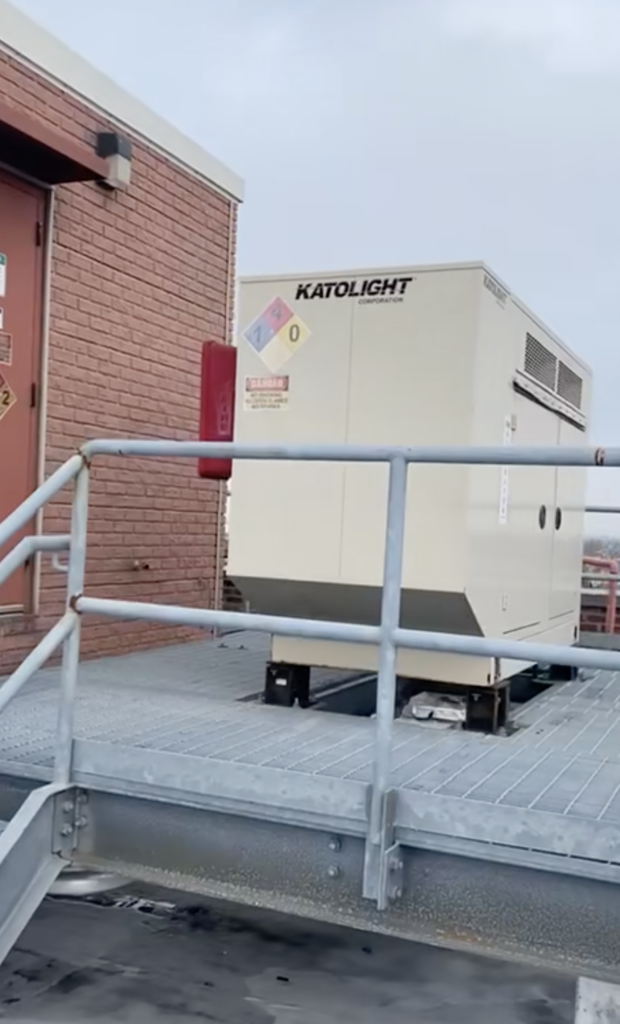 AT&T rooftop cell site Queens NYC with a generator on a raised steel platform.