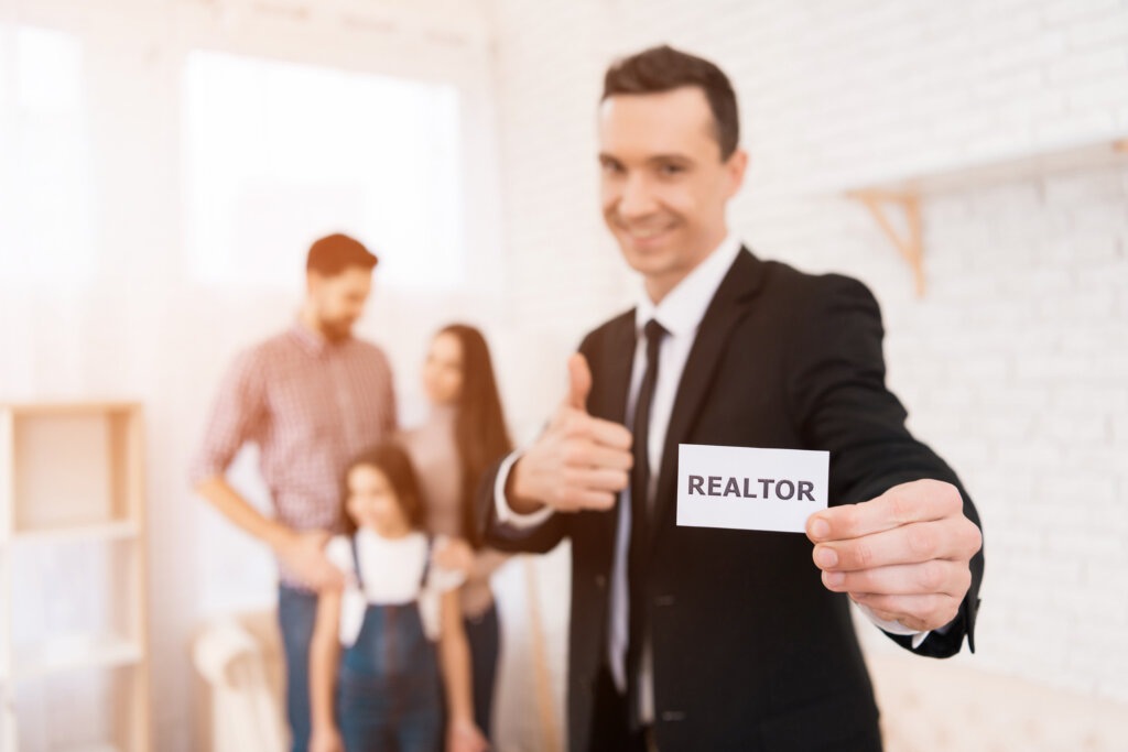 Realtor showing homes to a family in the backgorund