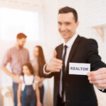 Realtor showing homes to a family in the backgorund