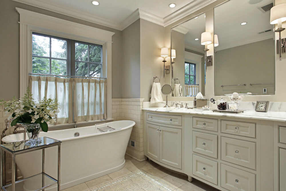 a
bathroom renovations
in Winnipeg with a large mirror and a tub