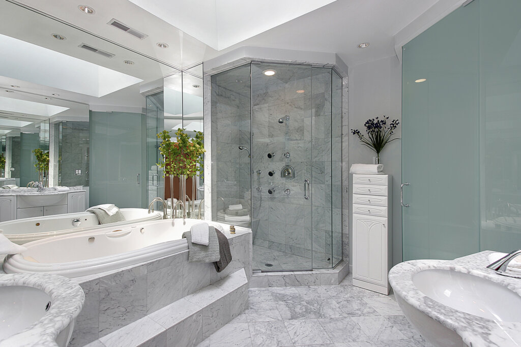 a bathroom renovations Winnipeg with a tub shower and large glass panel, there are green trees on the background