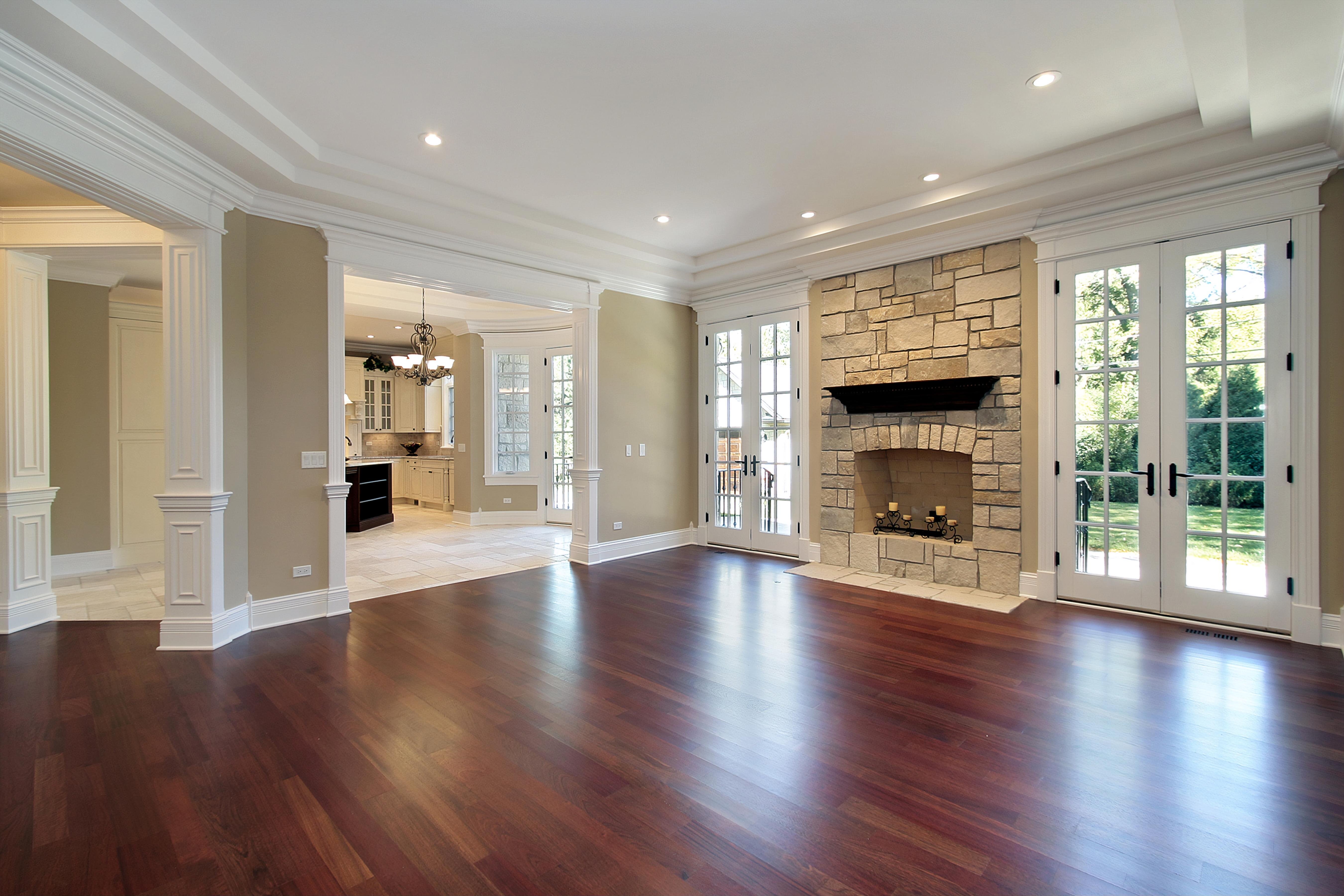 Flooring renovation Winnipeg large living room with a fireplace and hardwood floor