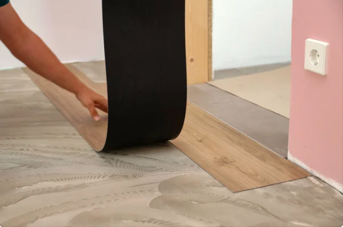 Flooring renovation Winnipeg person holding a black strip of wood