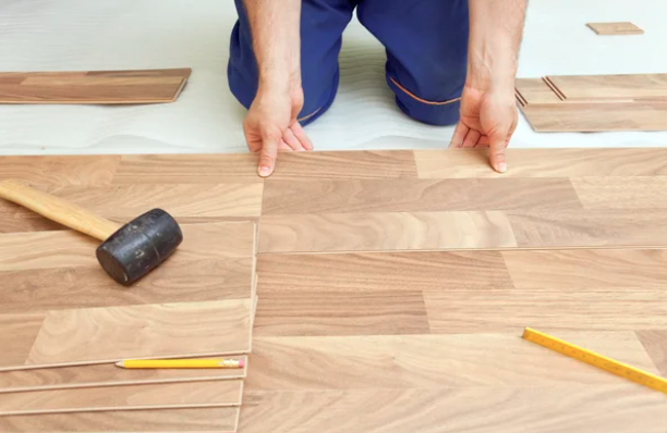Flooring renovation Winnipeg person measuring the length of a wooden floor
