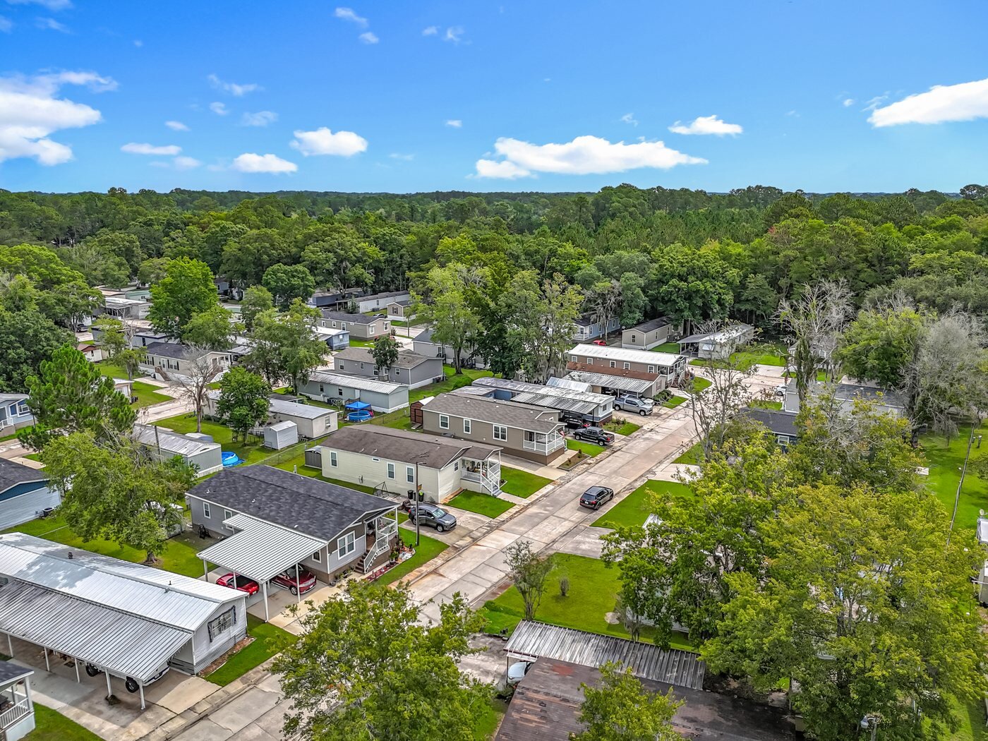 Aerial view of a mobile home community in Jacksonville, Florida, with paved streets, carports and mature trees