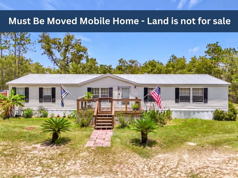 Well kept double wide mobile home with a metal roof, listed as must be moved with the land not for sale