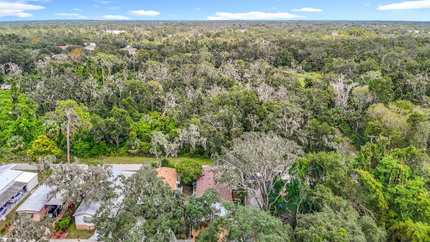 A mobile home listed by Florida Mobile Home Solutions in Riverview, Florida, in a wooded community setting
