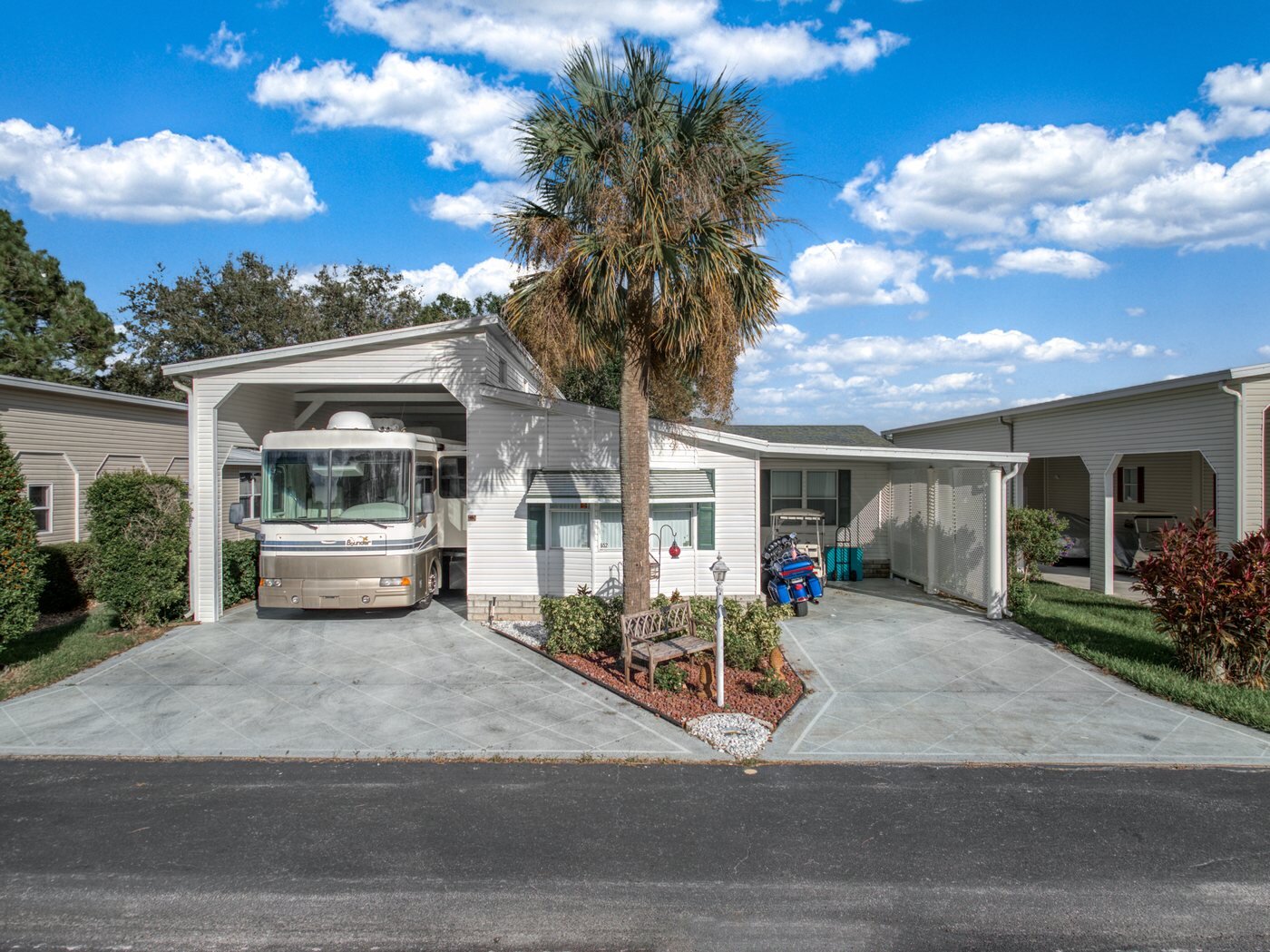A mobile home listed by Florida Mobile Home Solutions in Sebring, Florida, with a carport and covered RV parking