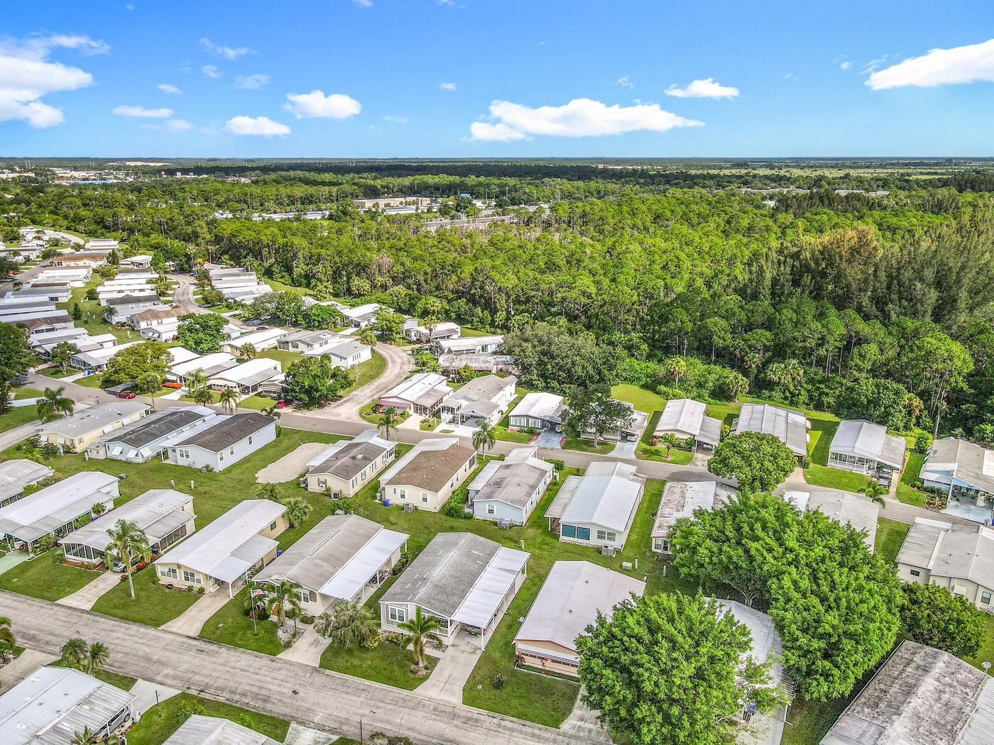 A mobile home listed by Florida Mobile Home Solutions in Vero Beach, Florida, in an established community with mature landscaping