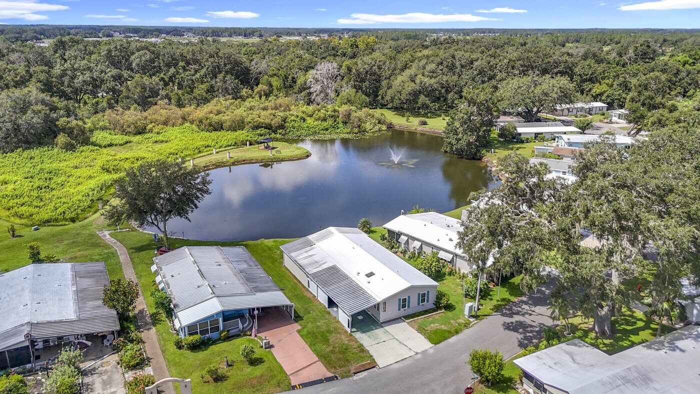 Aerial view of a mobile home community in Zephyrhills, Florida, with homes overlooking a lake