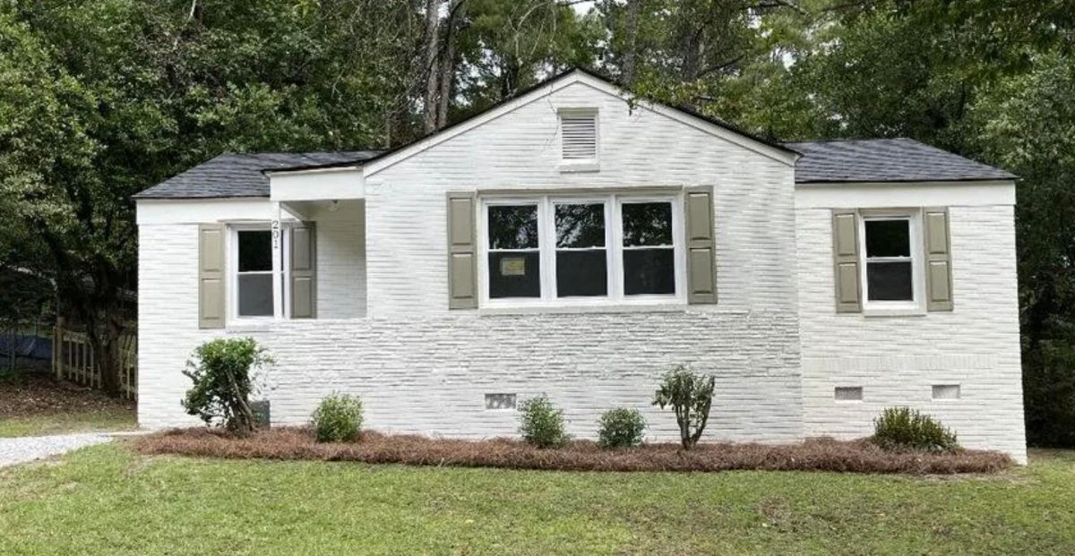 The same Greenville, SC house after renovation, painted white with new landscaping