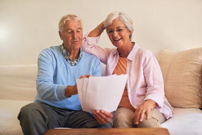 Elderly-couple-reading -documents-on-a-couch
