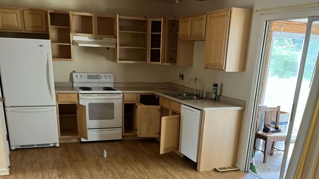 A clean and tidy kitchen with wooden shelves.