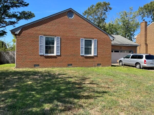 A House In Virginia Beach with open windows and a car parked by.