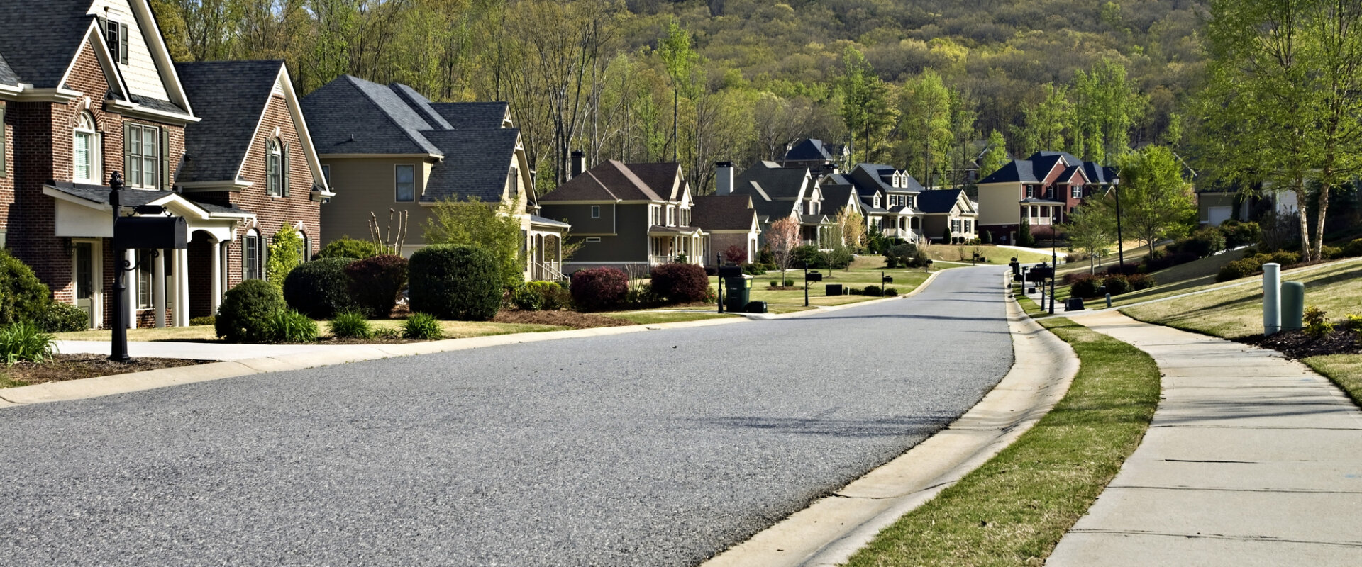 A paved road lined with quintessential Virginia homes, showcasing the vibrant Franklin community. Looking to sell your house fast Franklin VA homeowners? HR Property Doctor is here to help with cash home buying.