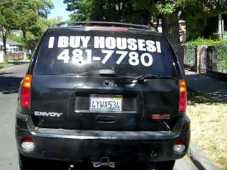 Truck with an I Buy Houses Stockton sign on the back.