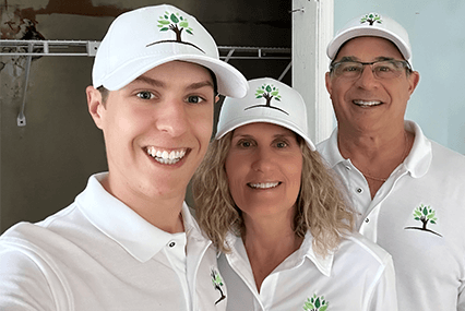 Anthony, Cynthia & Steve of Organic Home Solutions inside a distressed property wearing matching white logo hats and shirts