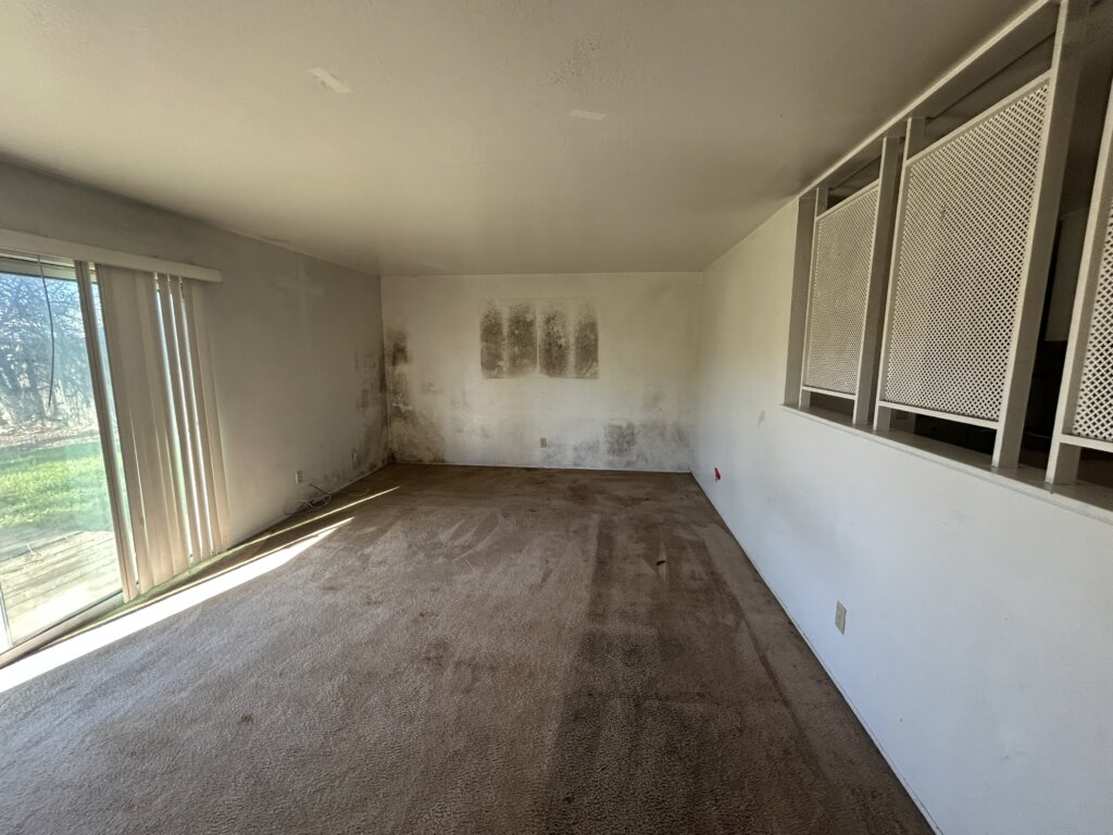 Quick Home Offers bought this CA home with mold. Mold is visible in the living room wall.