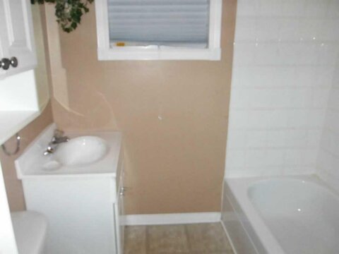Small bathroom with sink, bathtub, and window