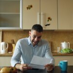 Hamilton homeowner reviewing financial documents at kitchen table