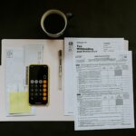 Tax withholding documents and financial forms spread on a dark desk surface representing CRA income tax debt situation for Hamilton homeowners