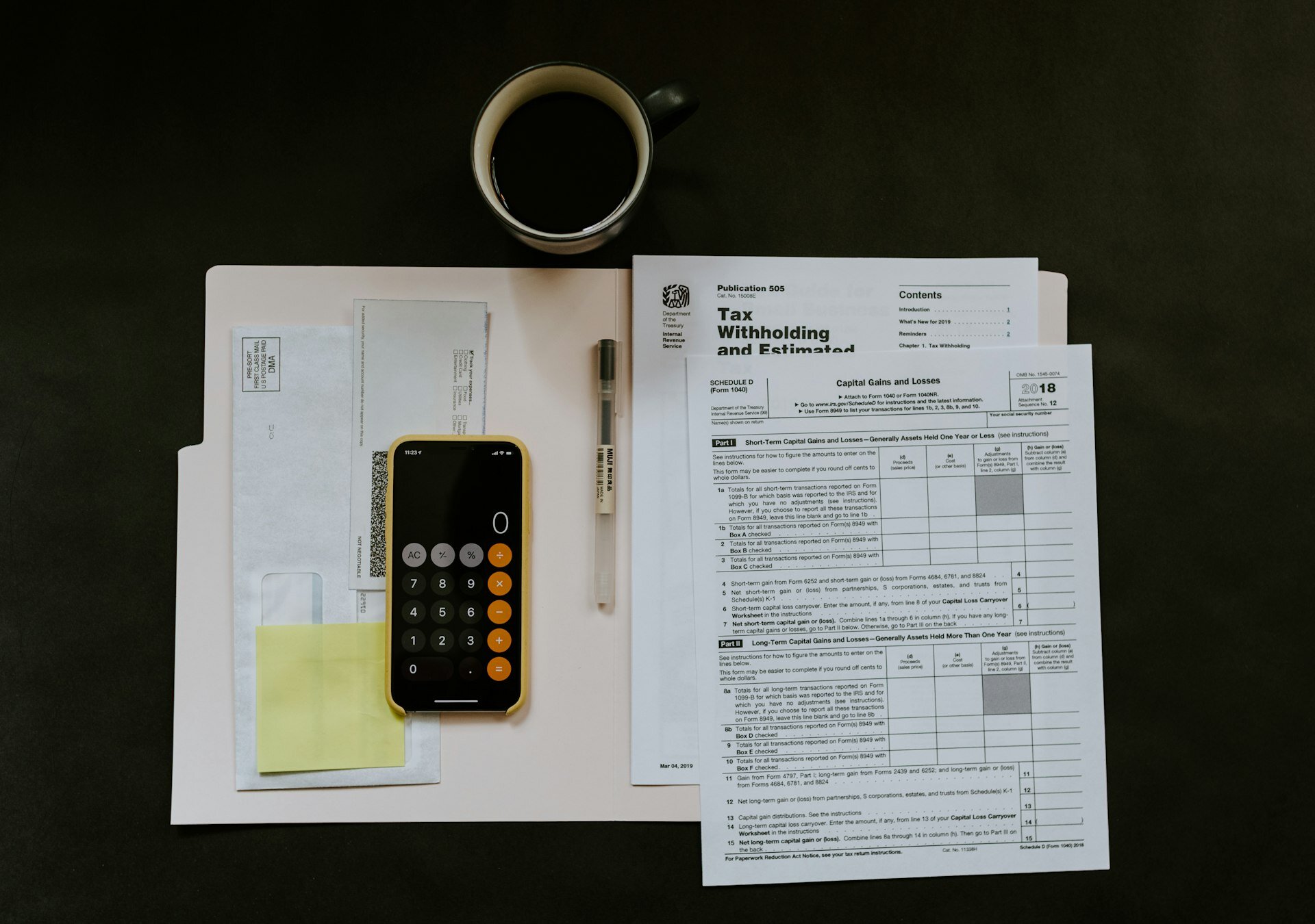 Tax withholding documents and financial forms spread on a dark desk surface representing CRA income tax debt situation for Hamilton homeowners