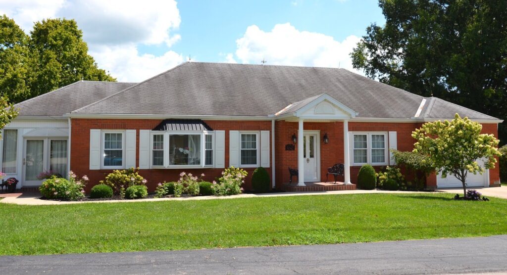Single-story brick house with white shutters and a front lawn