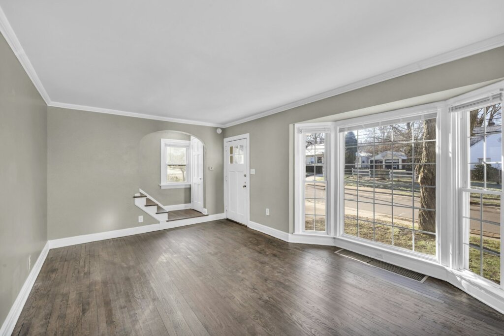Empty living room with a bay window and bare walls