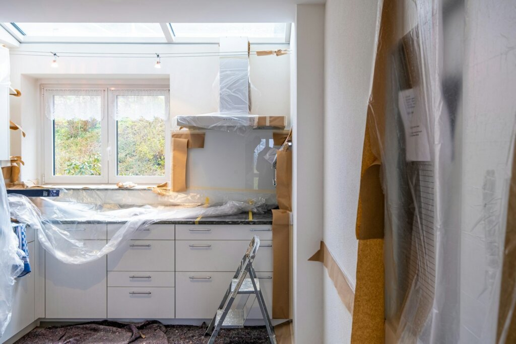 Kitchen mid-renovation with cabinets covered and unfinished counters