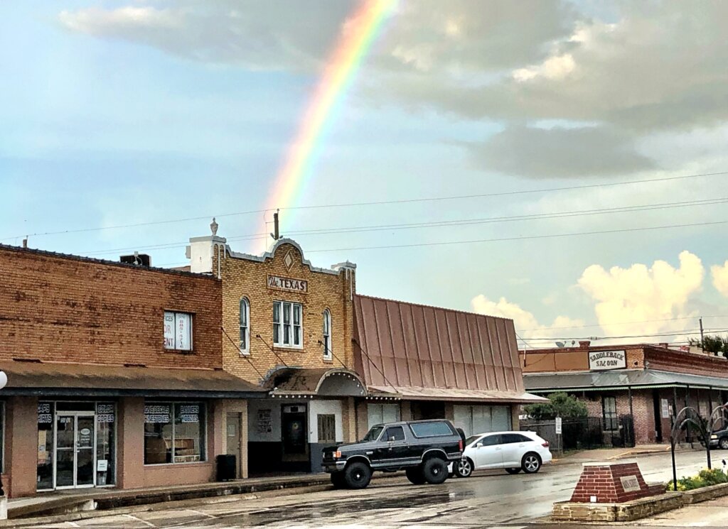 Picture of downtown Sealy, Texas with a rainbow behind one of the buildings.