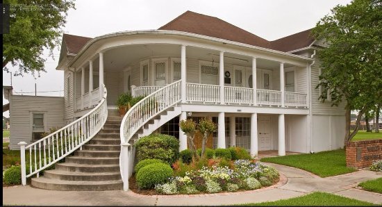 Famous house in Brookshire, Texas with a beautiful stair way leading to a wrap around balcony on second floor.
