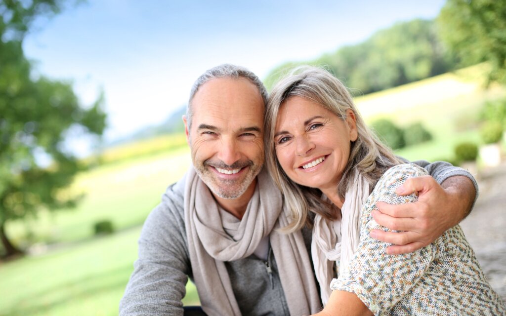 Happy couple at a park after they sold their house to a cash home buyer.