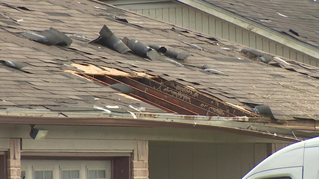 Roof that has shingles, in Katy, TX, that are peeling back and a section of the roof with a big hole.