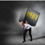 Man being crushed by a giant concrete block with the word debt on it. This man is facing foreclosure and doesn't know how he will escape the debt.
