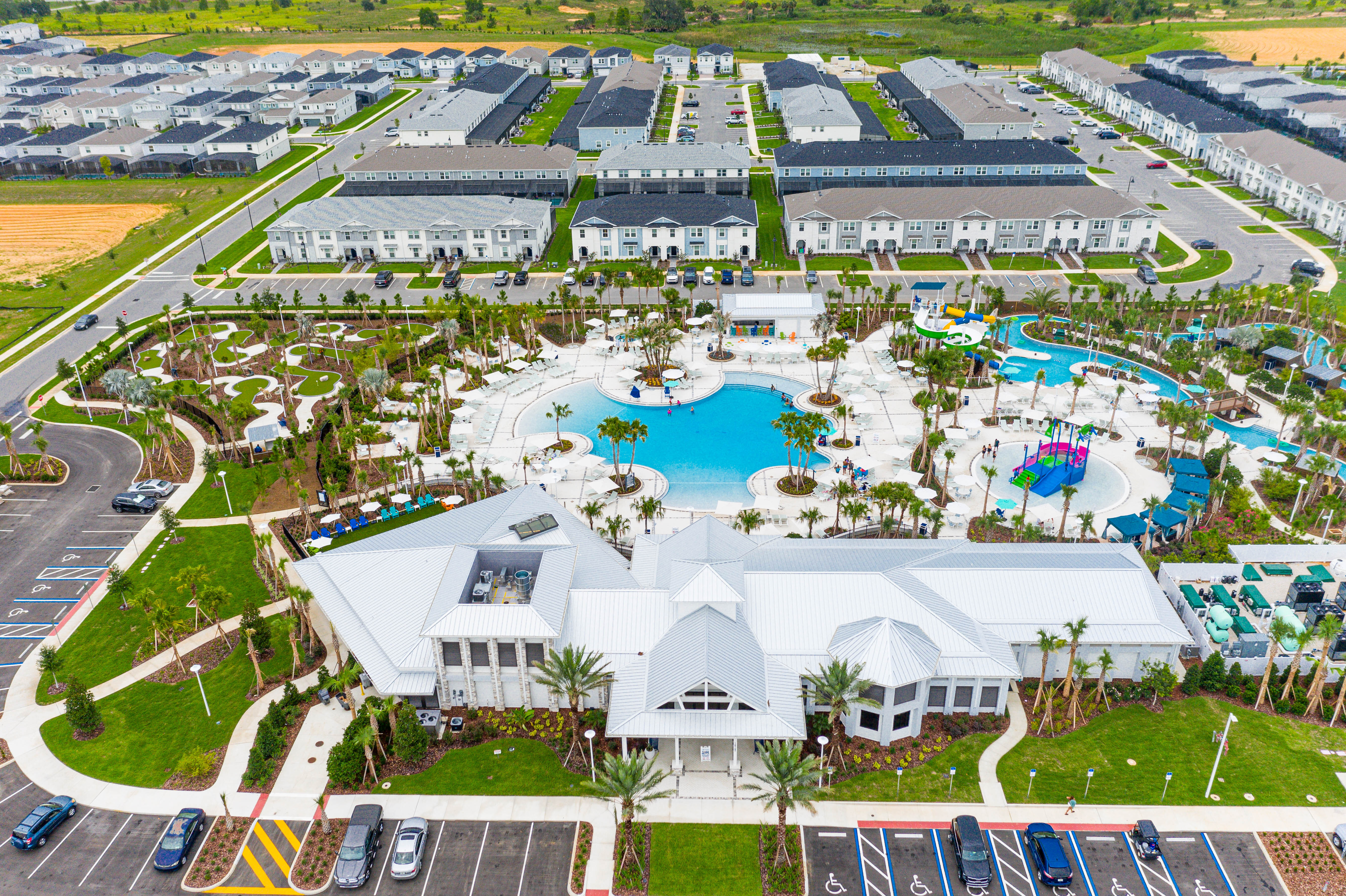 Aerial view of Windsor Cay Resort featuring the clubhouse, resort-style pool, water slides, and surrounding vacation homes near Disney.