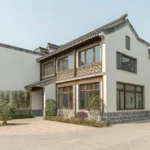 Traditional-style residential house with white walls, decorative windows, tiled roof, and landscaped front entrance.