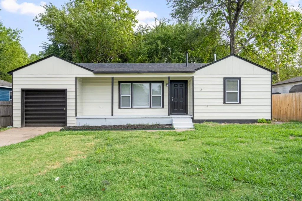 Renovated single-story home with attached garage and fresh green lawn, bought for cash in Tulsa
